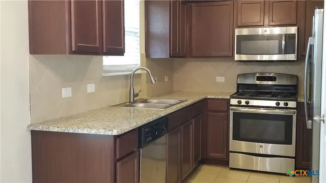 a kitchen with a sink stove and microwave