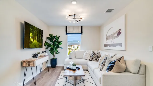 a living room with furniture a chandelier and a flat screen tv