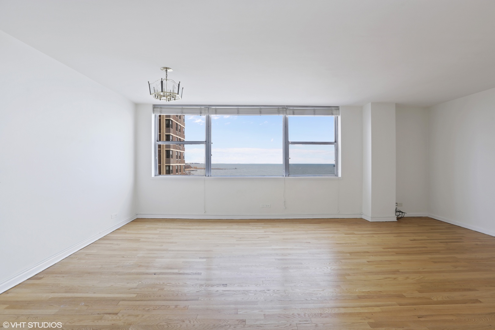 6301 North Sheridan Road, Unit 10L Chicago, IL 60660 - Photo 3 of 14 an empty room with wooden floor and windows