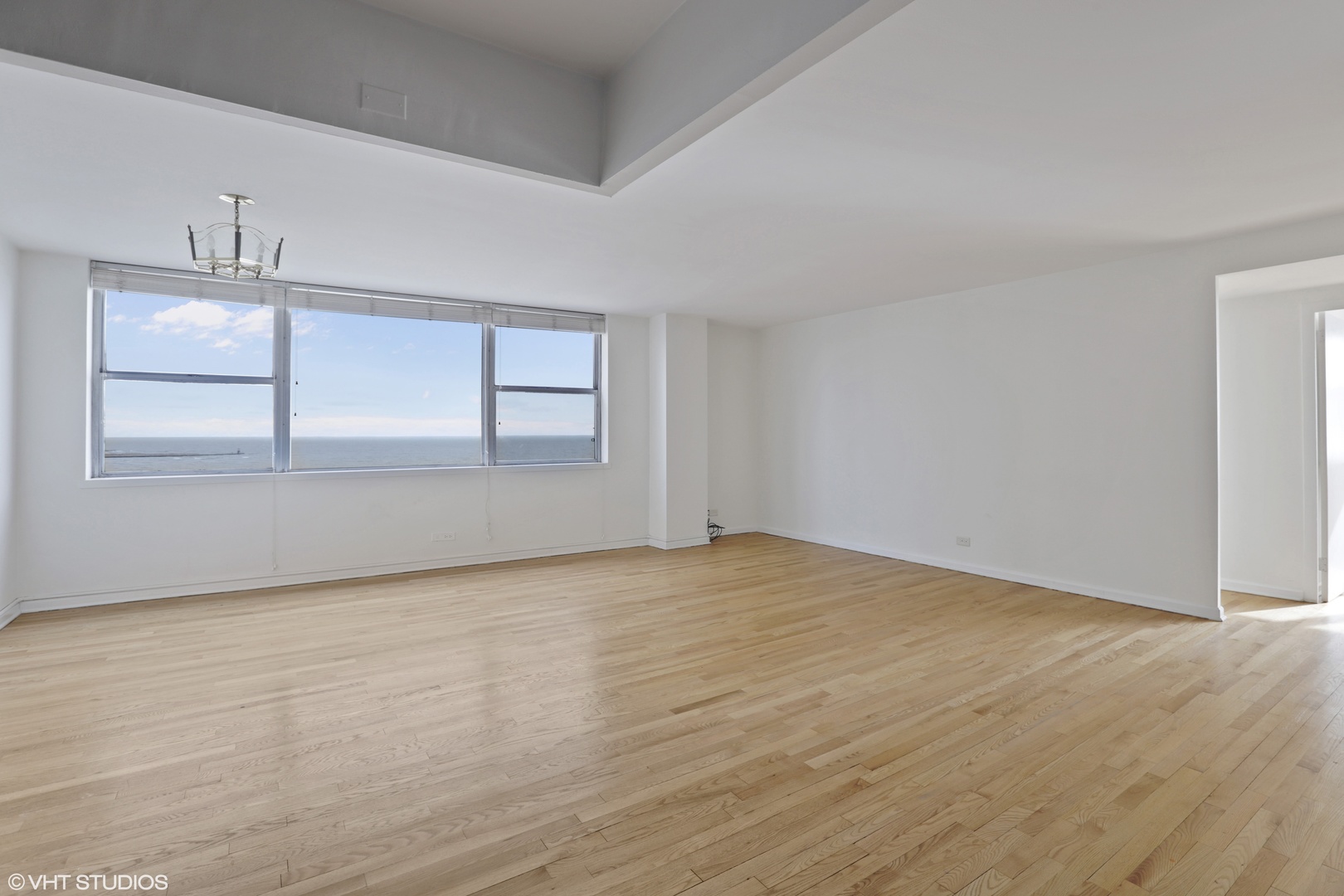 6301 North Sheridan Road, Unit 10L Chicago, IL 60660 - Photo 4 of 14 an empty room with wooden floor and windows