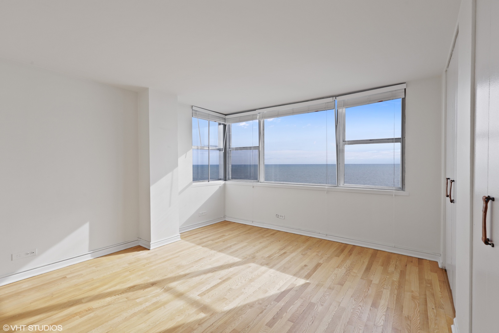 6301 North Sheridan Road, Unit 10L Chicago, IL 60660 - Photo 6 of 14 a view of an empty room with wooden floor and a window