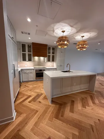 a kitchen with kitchen island granite countertop a sink and white cabinets