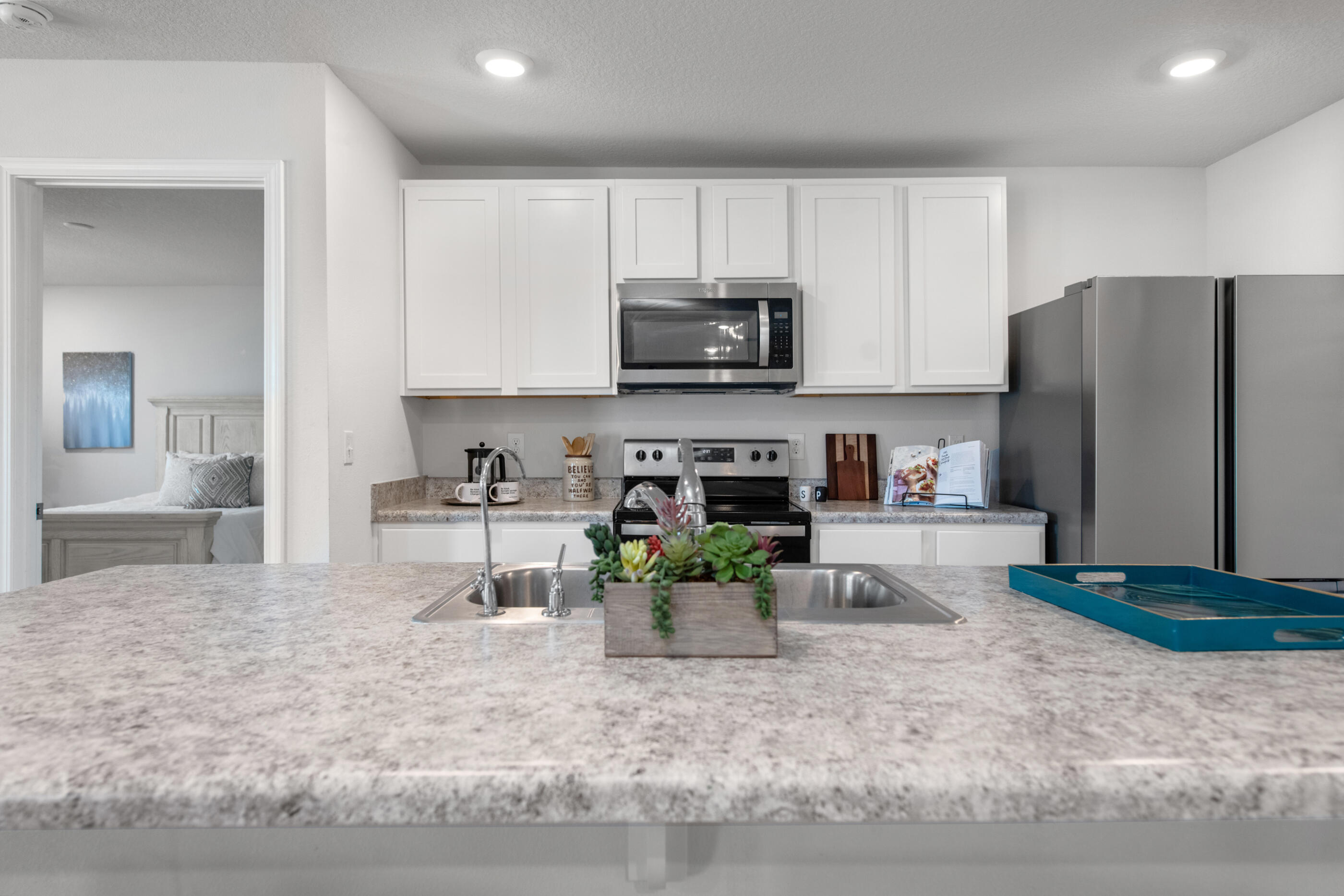 193 This Way Freeport, FL 32439 - Photo 10 of 56 a kitchen with stainless steel appliances granite countertop a stove a refrigerator a sink a stove and white cabinets