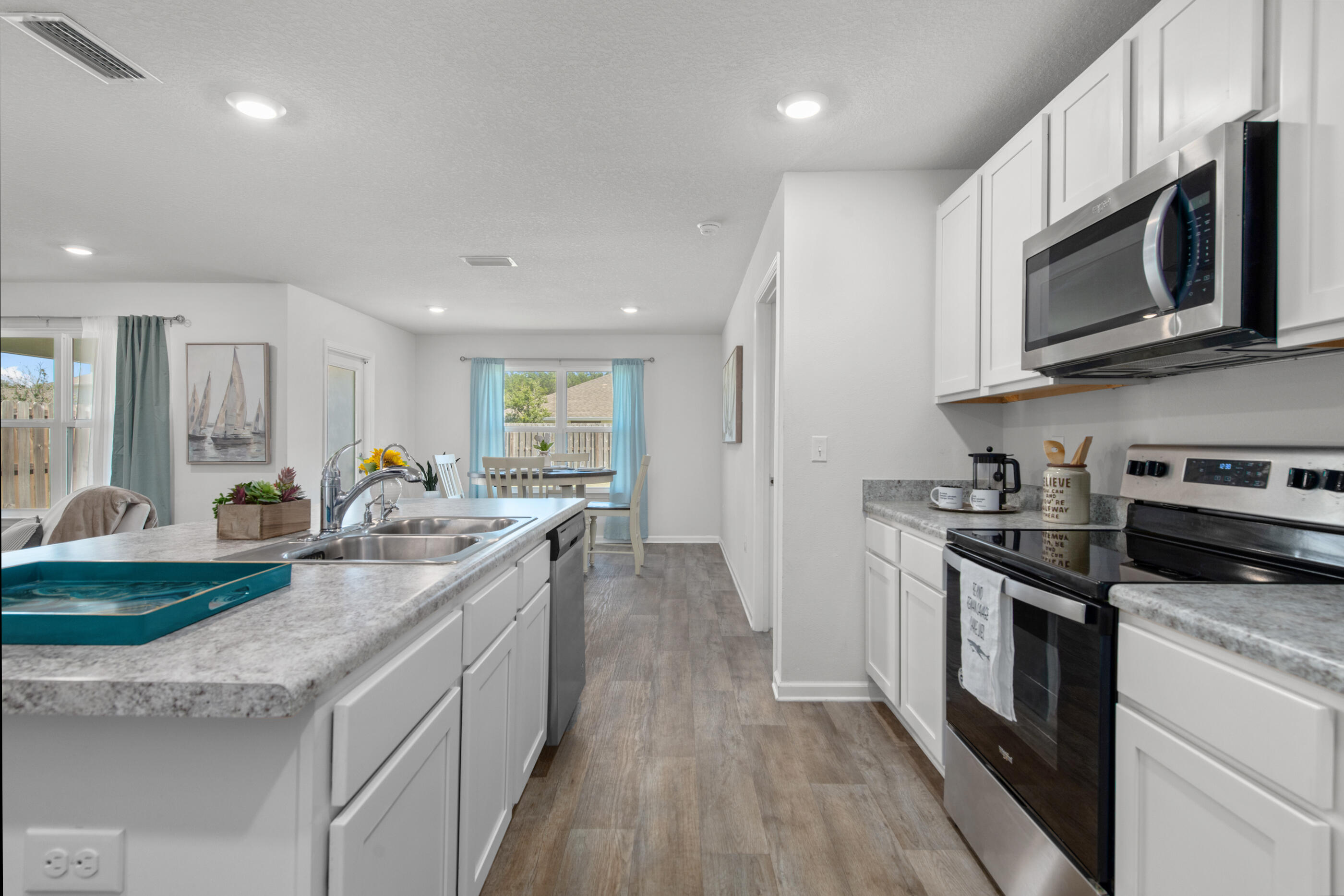 193 This Way Freeport, FL 32439 - Photo 8 of 56 a kitchen with stainless steel appliances granite countertop a stove a sink and a microwave