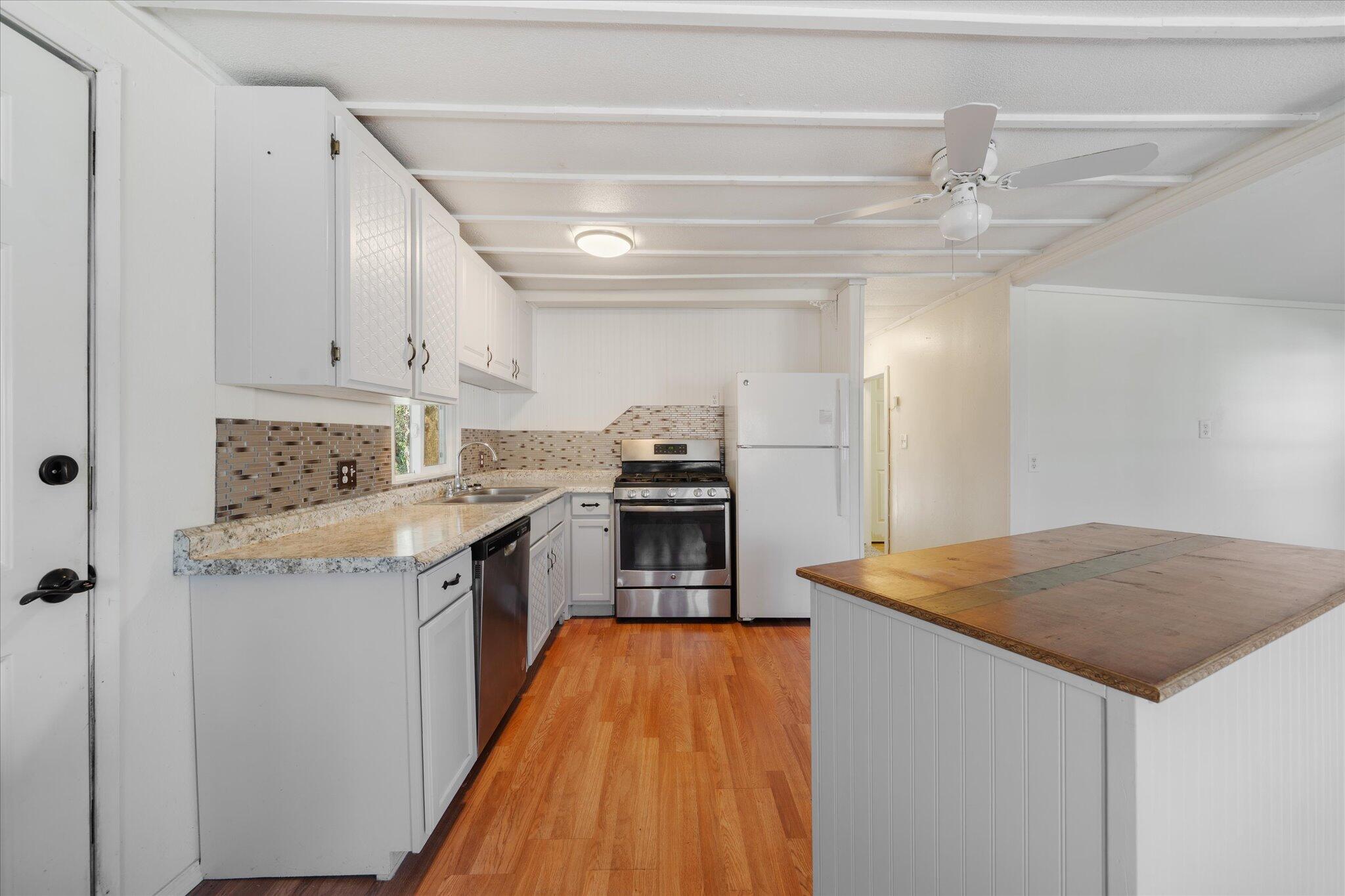 3150 Haley Lane Redding, CA 96003 - Photo 7 of 23 a kitchen with granite countertop a stove and a refrigerator