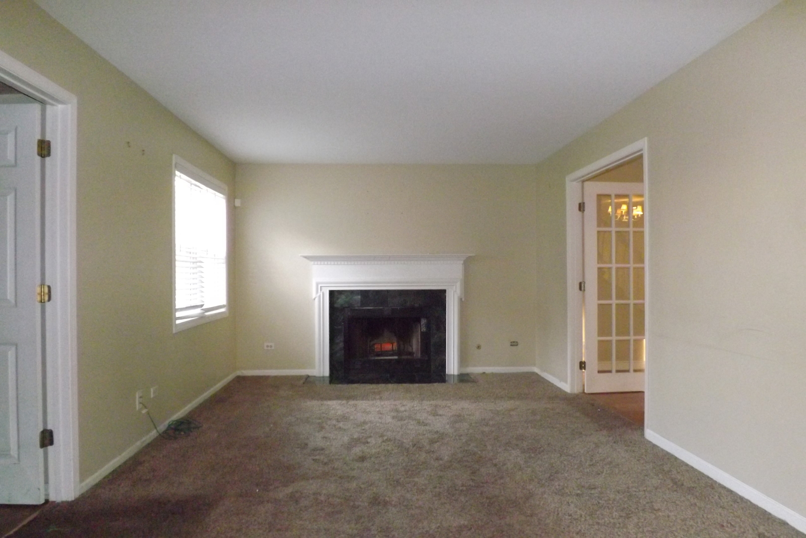 2325 Caton Corner Plainfield, IL 60586 - Photo 2 of 11 an empty room with a fireplace and window