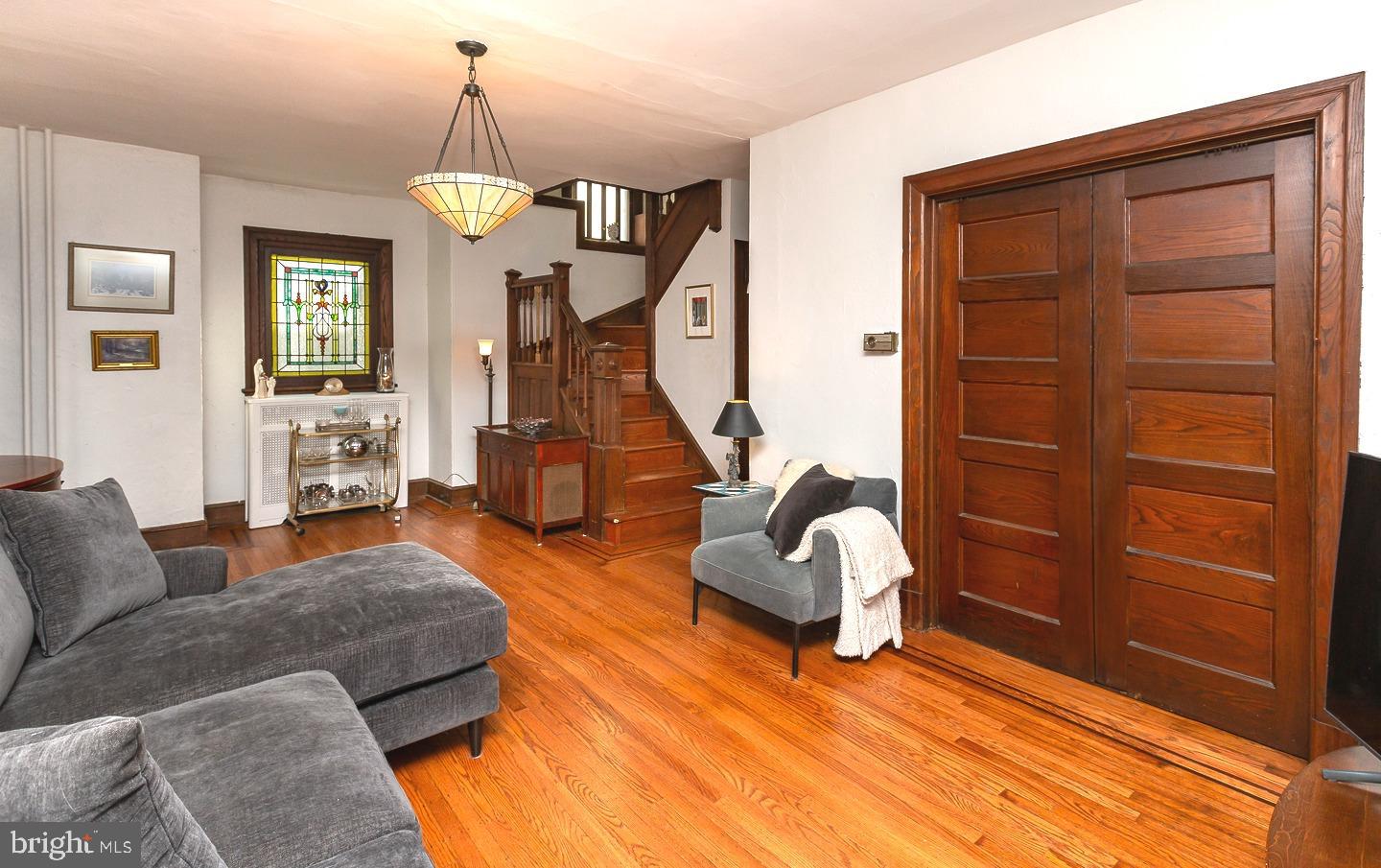 251 Sagamore Road Havertown, PA 19083 - Photo 7 of 41 a living room with furniture a wooden floor and a chandelier