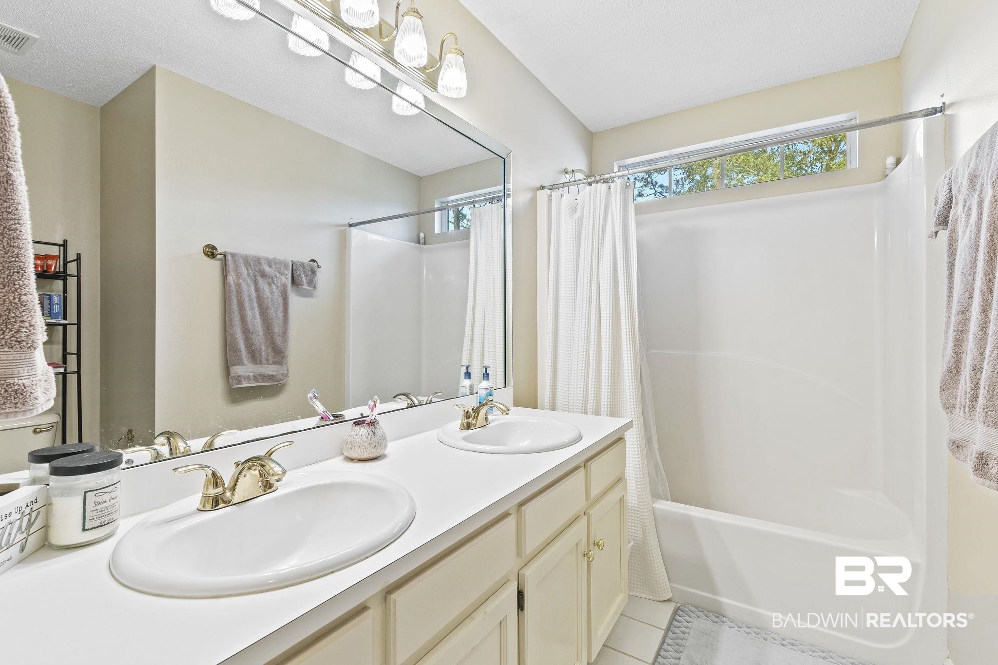 22 Pirates Lane Daphne, AL 36527 - Photo 26 of 36 Bathroom with shower / bath combo with shower curtain, tile patterned flooring, and vanity