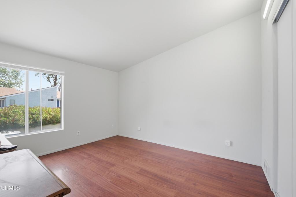 5154 Jefferson Square Oxnard, CA 93033 - Photo 21 of 23 an empty room with wooden floor and windows