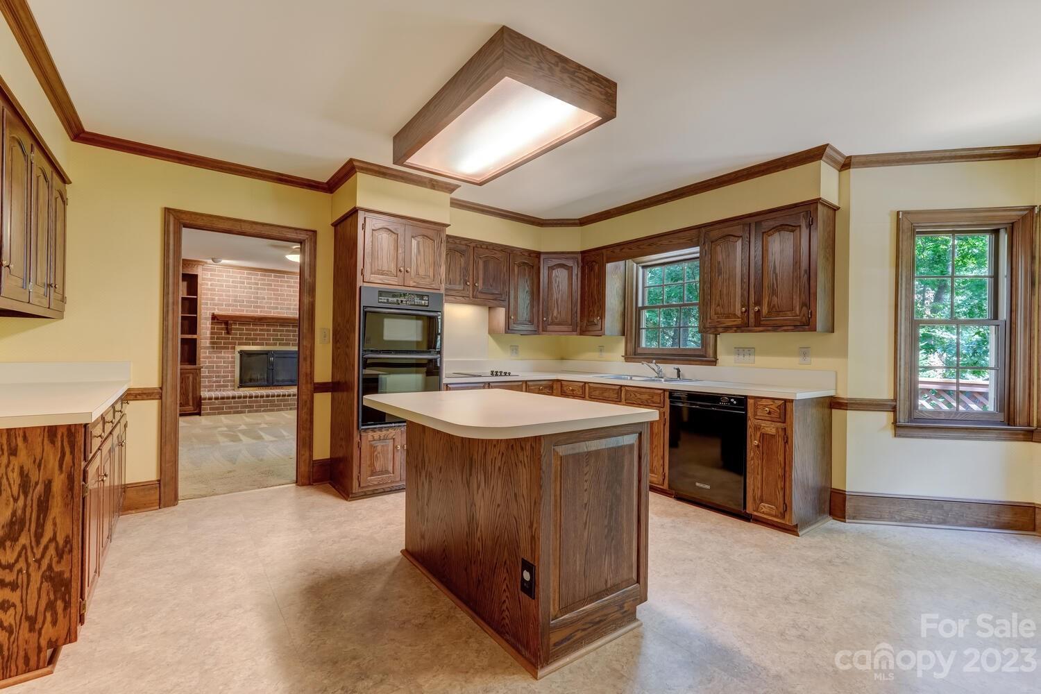 10215 Hanover Glen Road Charlotte, NC 28210 - Photo 11 of 40 a kitchen with kitchen island granite countertop a stove top oven a sink dishwasher a dining table and chairs with wooden floor