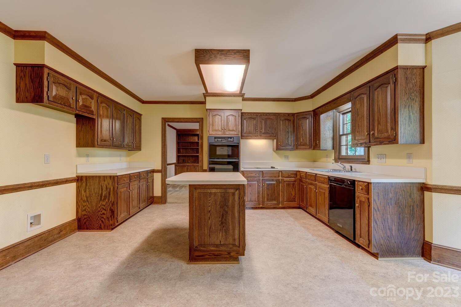 10215 Hanover Glen Road Charlotte, NC 28210 - Photo 12 of 40 a kitchen with stainless steel appliances kitchen island granite countertop a stove top oven a sink dishwasher a dining table and chairs with wooden floor
