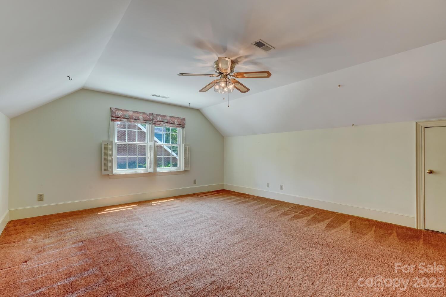 10215 Hanover Glen Road Charlotte, NC 28210 - Photo 32 of 40 an empty room with windows and chandelier fan