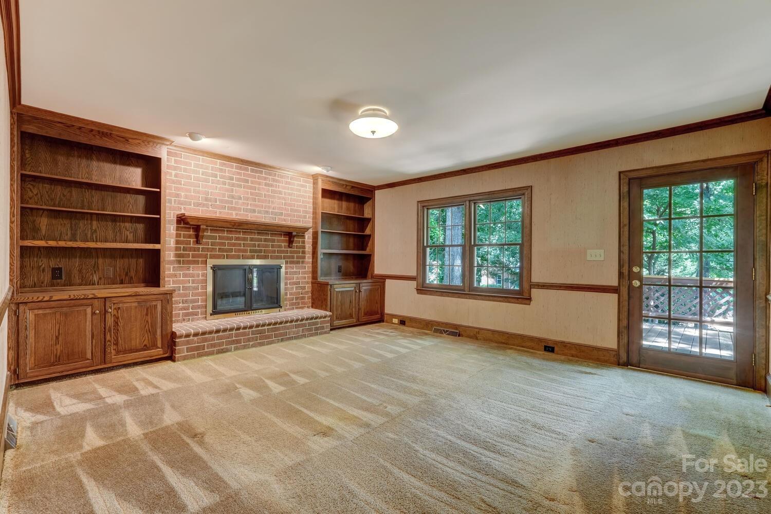 10215 Hanover Glen Road Charlotte, NC 28210 - Photo 8 of 40 a view of an empty room with a fireplace and a window