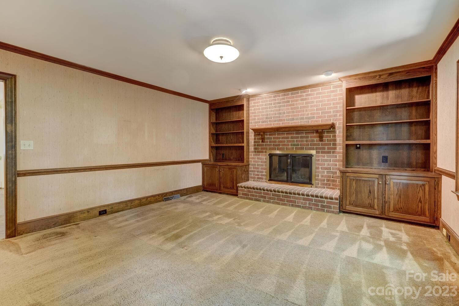 10215 Hanover Glen Road Charlotte, NC 28210 - Photo 10 of 40 a view of an empty room with a fireplace and a window