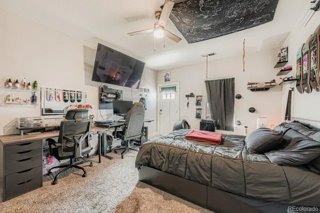 a bedroom with a bed a flat screen tv and dresser
