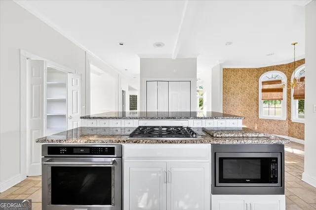 a kitchen with granite countertop a stove and a sink