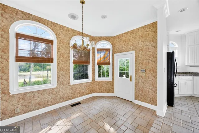a kitchen with white cabinets appliances a sink and a window