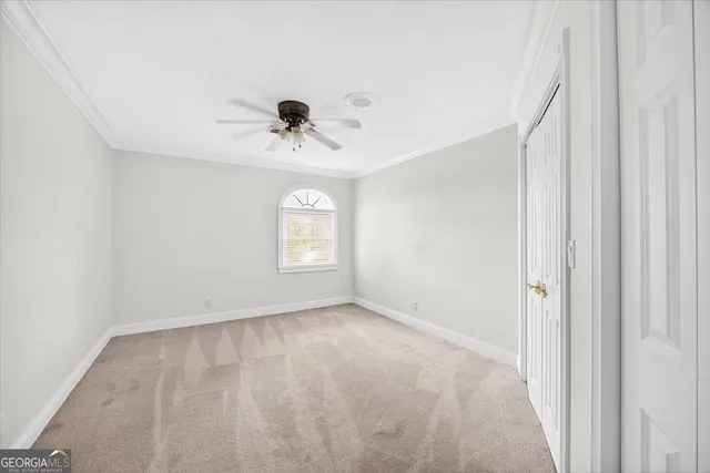 a view of an empty room and chandelier fan