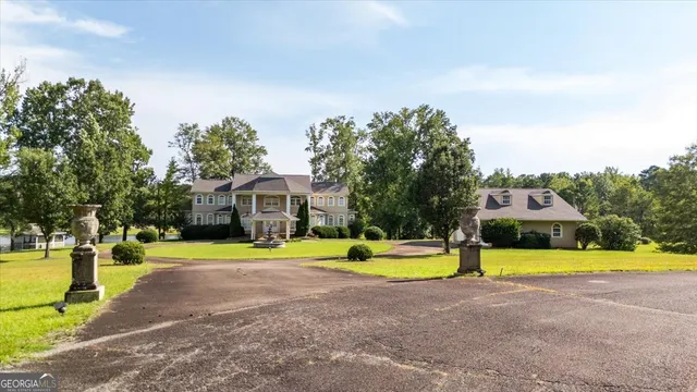 a view of an swimming pool with a big yard and large trees