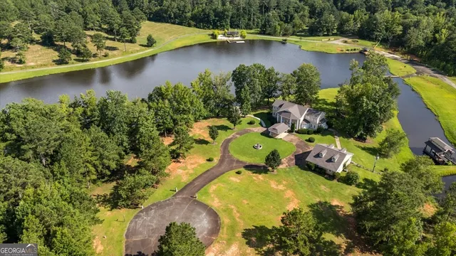 an aerial view of a house with a yard and lake view
