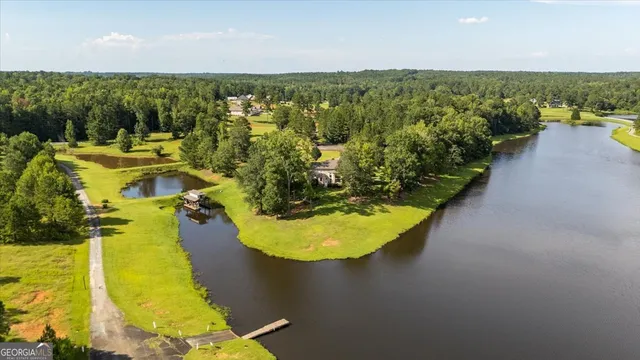 an aerial view of a house with swimming pool a yard and outdoor seating