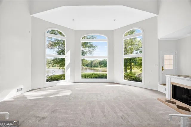 an empty room with windows and fireplace