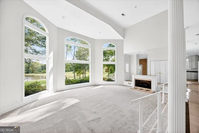 a living room with a large window and a fireplace