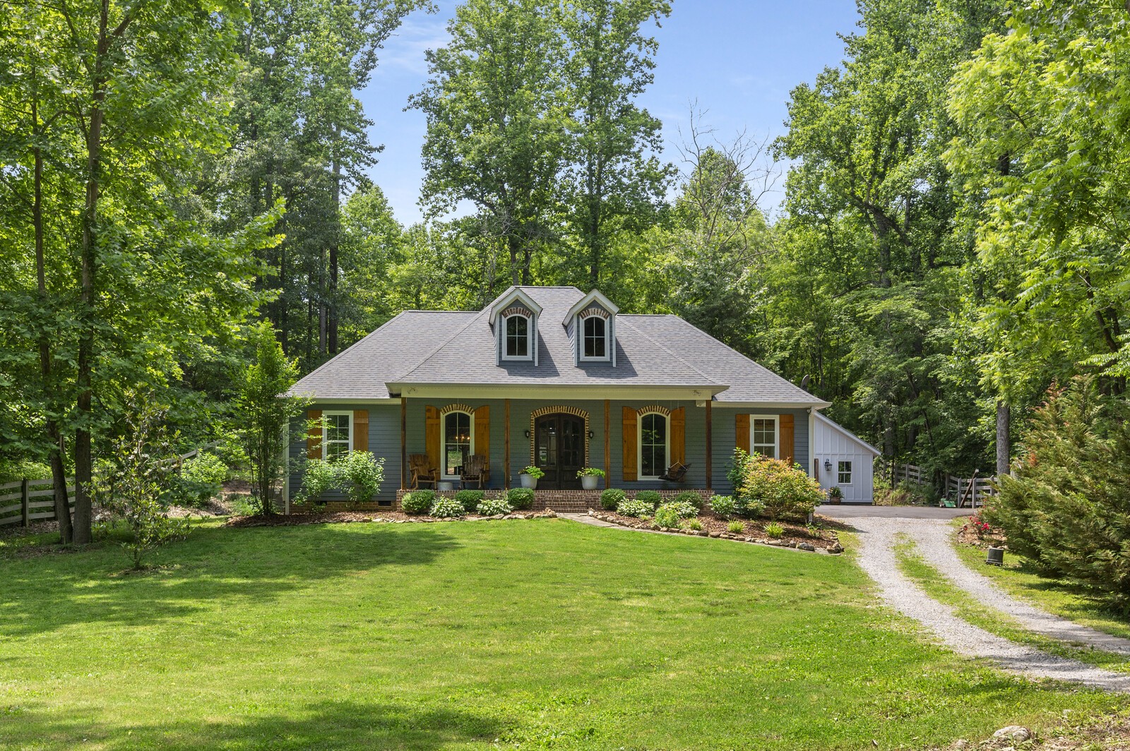 1082 Meeks Cemetery Road Burns, TN 37029 - Photo 1 of 26 a front view of a house with a garden and trees