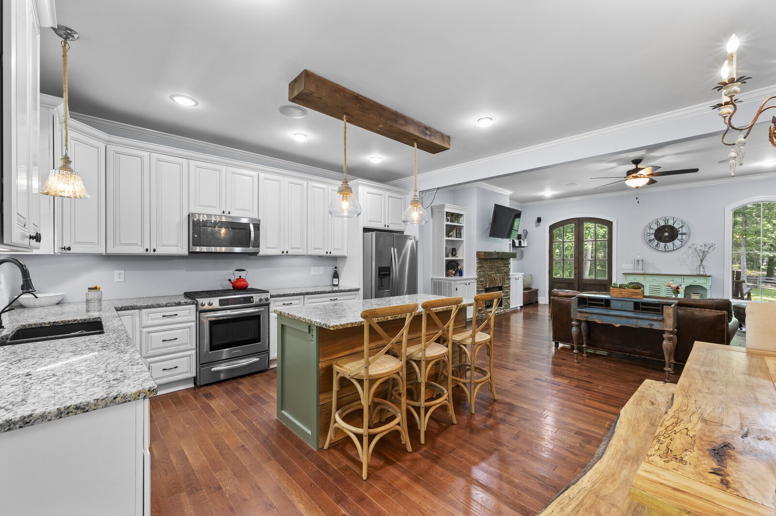 1082 Meeks Cemetery Road Burns, TN 37029 - Photo 9 of 26 a kitchen with stainless steel appliances granite countertop a stove top oven a sink dishwasher a dining table and chairs with wooden floor