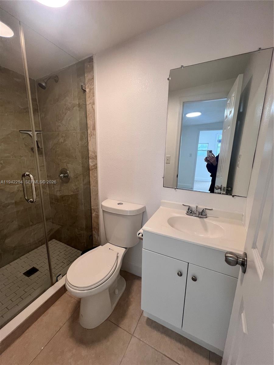 14763 Southwest 173rd Terrace, Unit 1 Miami, FL 33187 - Photo 23 of 23 a bathroom with a toilet sink shower and a mirror