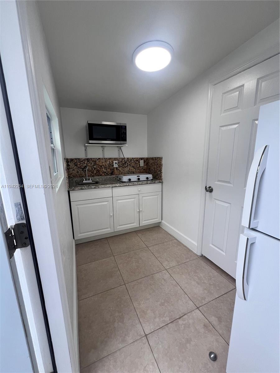 14763 Southwest 173rd Terrace, Unit 1 Miami, FL 33187 - Photo 6 of 23 a kitchen with stainless steel appliances a stove a refrigerator and a sink