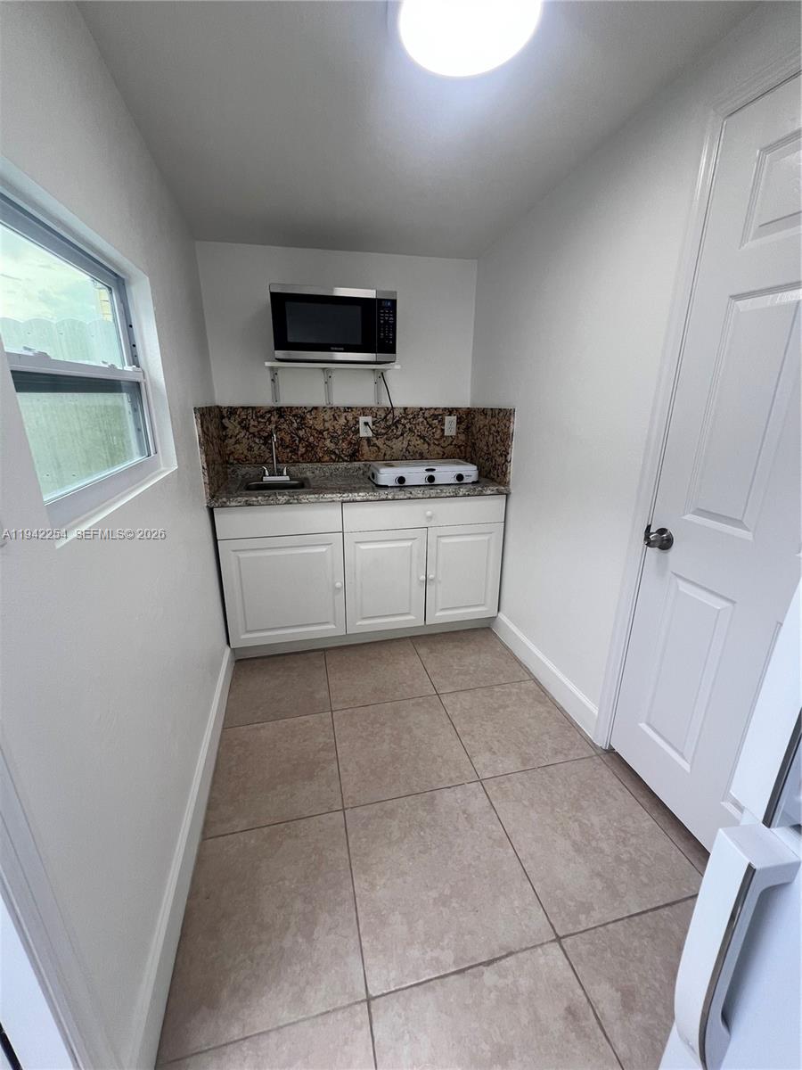 14763 Southwest 173rd Terrace, Unit 1 Miami, FL 33187 - Photo 8 of 23 a kitchen with a stove a sink and a microwave