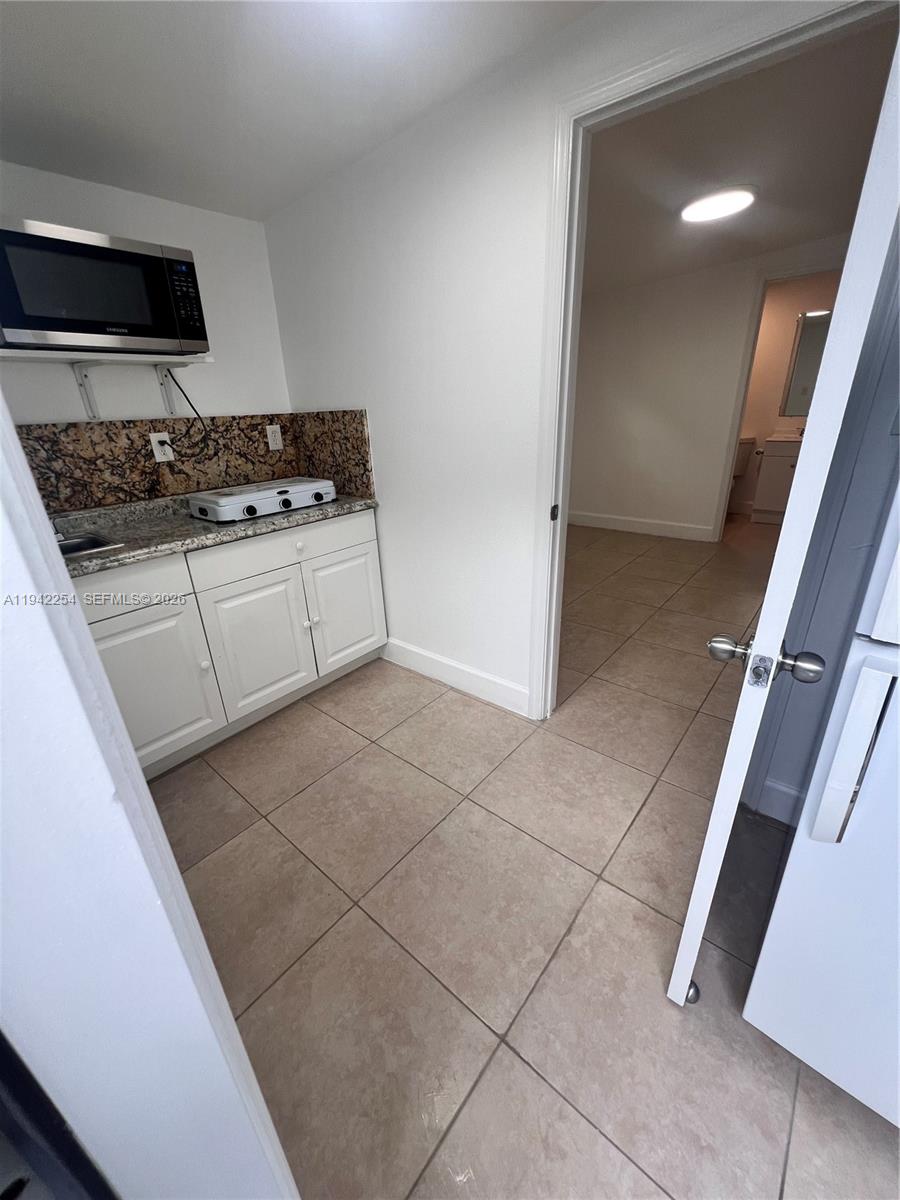 14763 Southwest 173rd Terrace, Unit 1 Miami, FL 33187 - Photo 9 of 23 a kitchen with a stove and a refrigerator