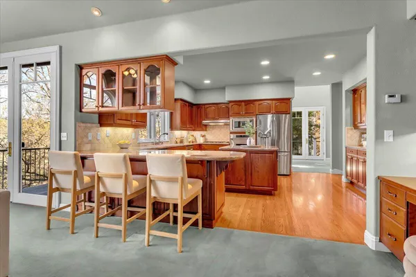 a dining room with stainless steel appliances kitchen island granite countertop a table and chairs