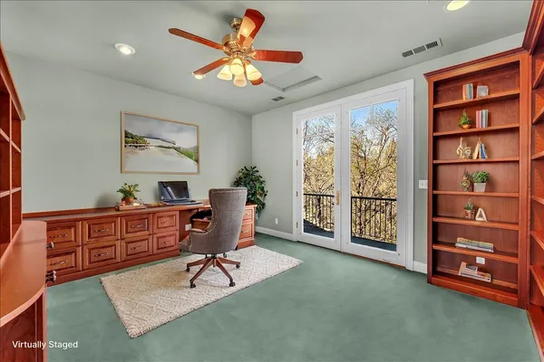 a view of a workspace with furniture and a window