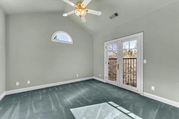 an empty room with windows and fan
