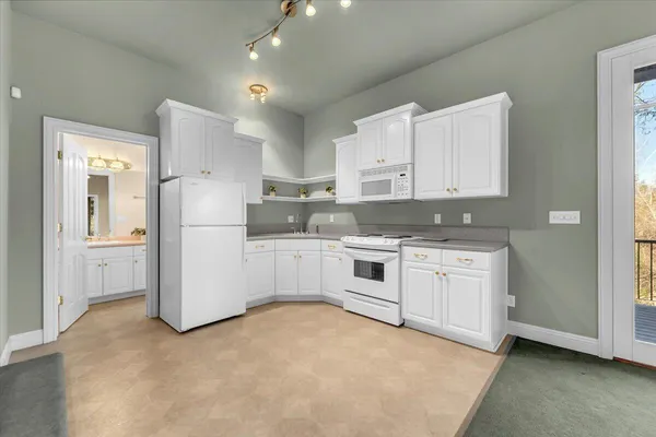 a kitchen with white cabinets and white appliances