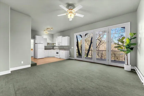 a view of a kitchen with refrigerator cabinet and a ceiling fan