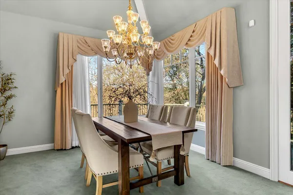 a view of a dining room with furniture and a chandelier