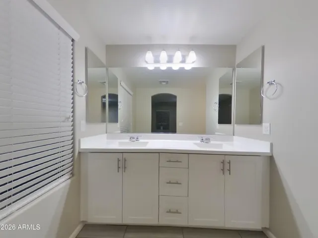 a view of an empty room with a chandelier fan