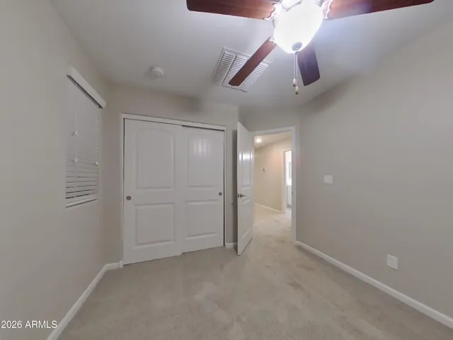 an empty room with closet and fan