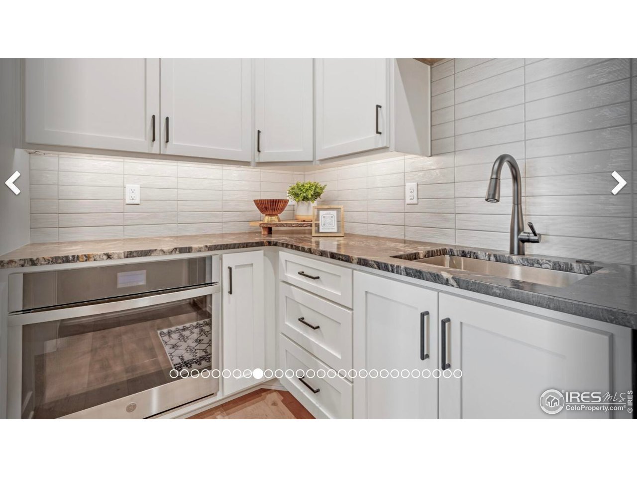 3806 Bridle Ridge Circle Severance, CO 80524 - Photo 5 of 13 a kitchen with granite countertop white cabinets and white appliances