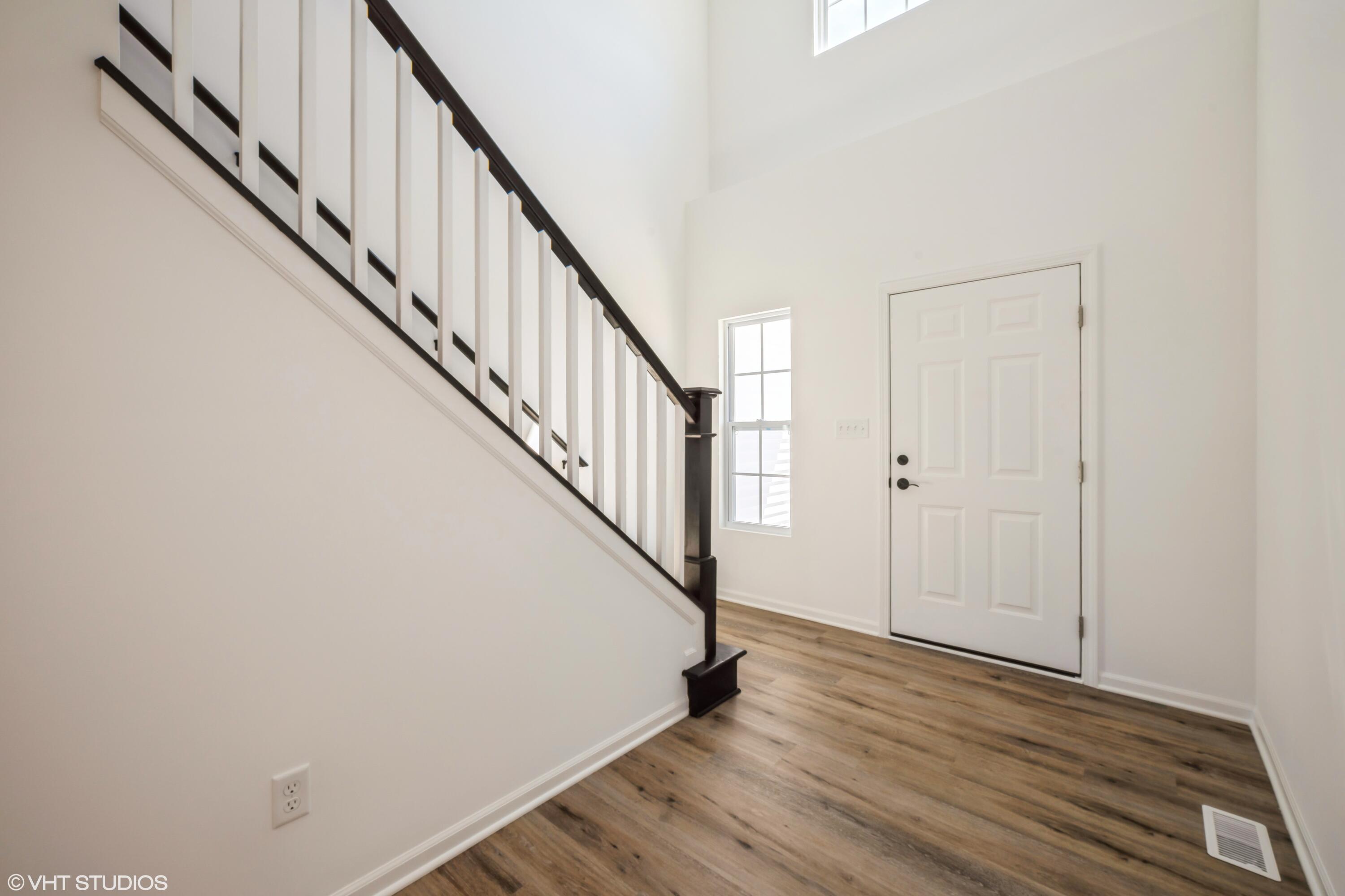 2885 East 105th Avenue Crown Point, IN 46307 - Photo 4 of 30 a view of a hallway with wooden floor and staircase