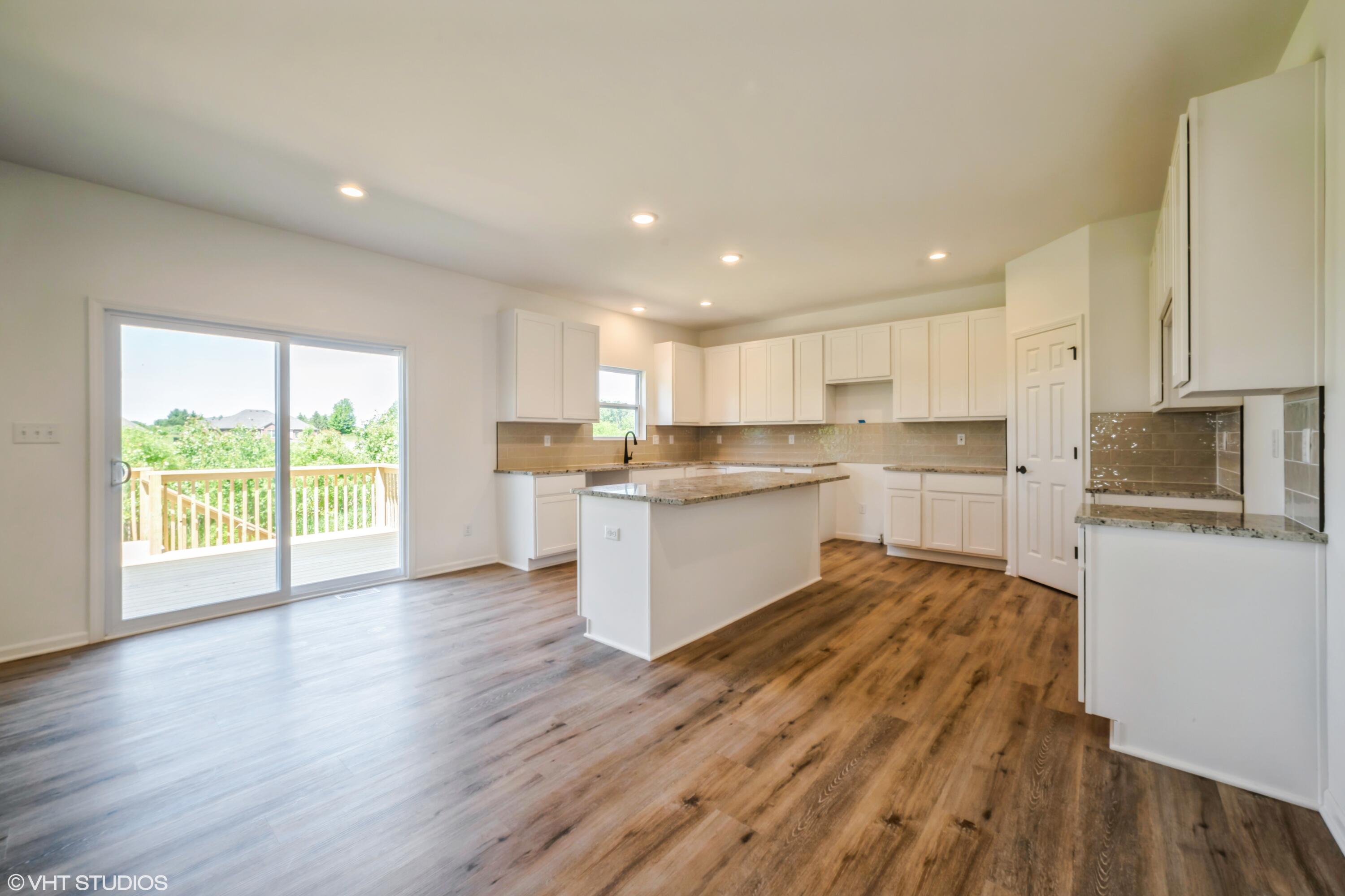 2885 East 105th Avenue Crown Point, IN 46307 - Photo 9 of 30 a kitchen with wooden floors and white stainless steel appliances
