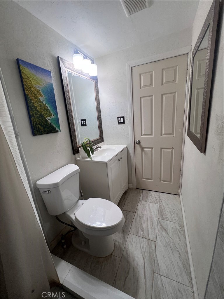20415 Myron Street Perris, CA 92570 - Photo 11 of 29 a white toilet sitting next to a bathroom sink