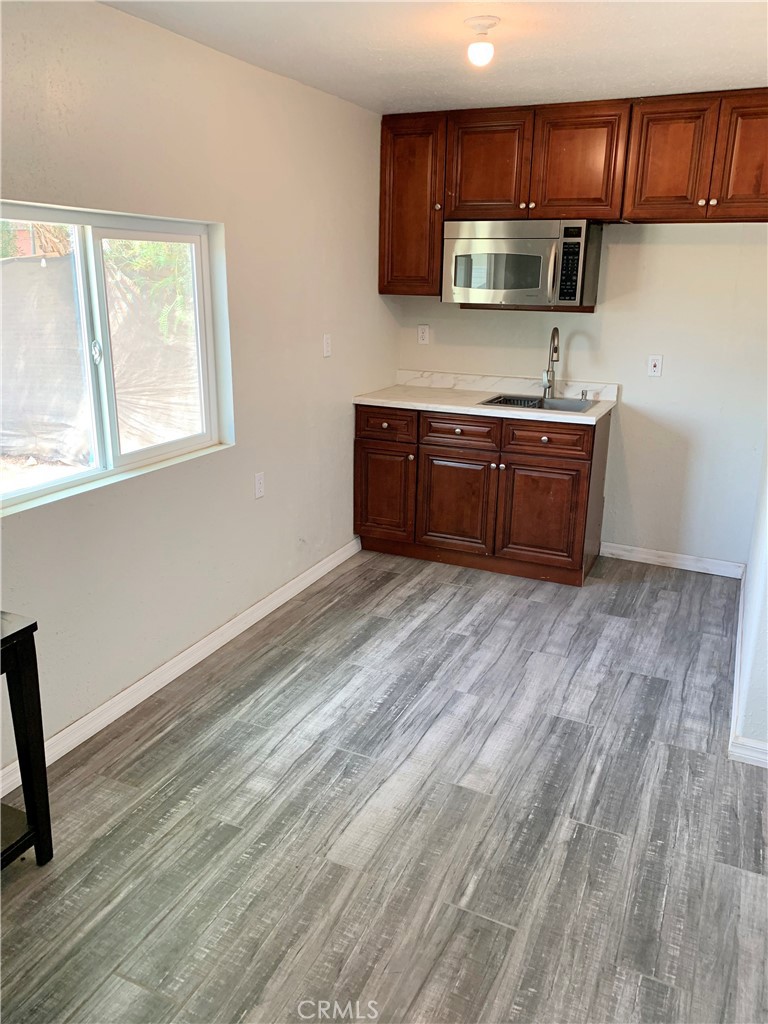 20415 Myron Street Perris, CA 92570 - Photo 29 of 29 a kitchen with stainless steel appliances wooden cabinets and a wooden floor