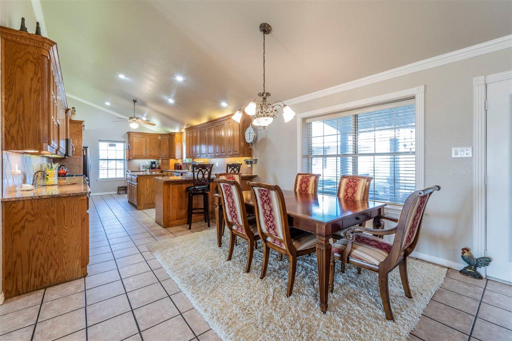 20175 Willow Glade Circle Pilot Point, TX 76258 - Photo 6 of 32 Dining space featuring a lovely chandelier, light tile patterned flooring, crown molding, and vaulted ceiling