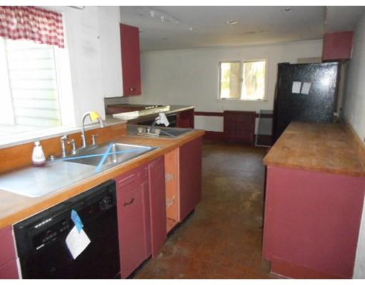 943 High Street Dedham, MA 02026 - Photo 8 of 25 a kitchen with kitchen island granite countertop a sink stove and cabinets