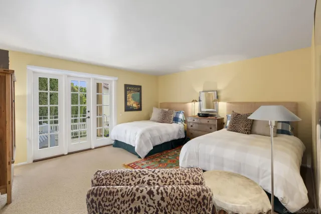 a bedroom with two beds and large window