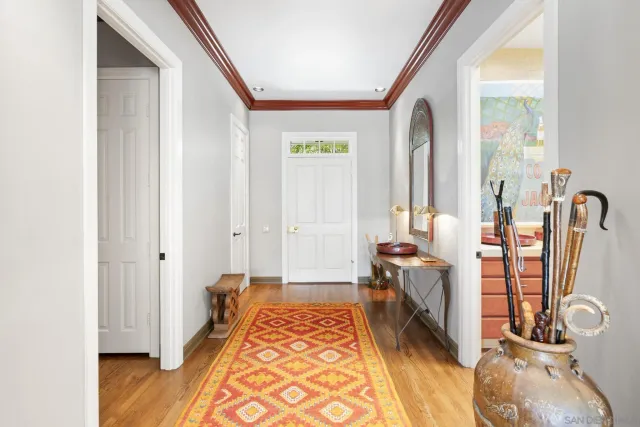 a view of a hallway with bathroom and wooden floor